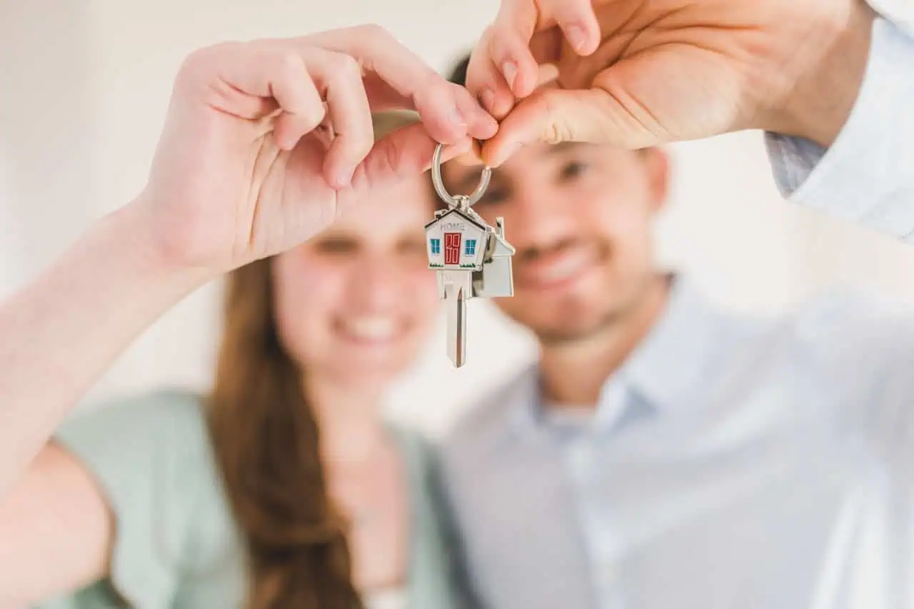 Couple holding keys to new house.